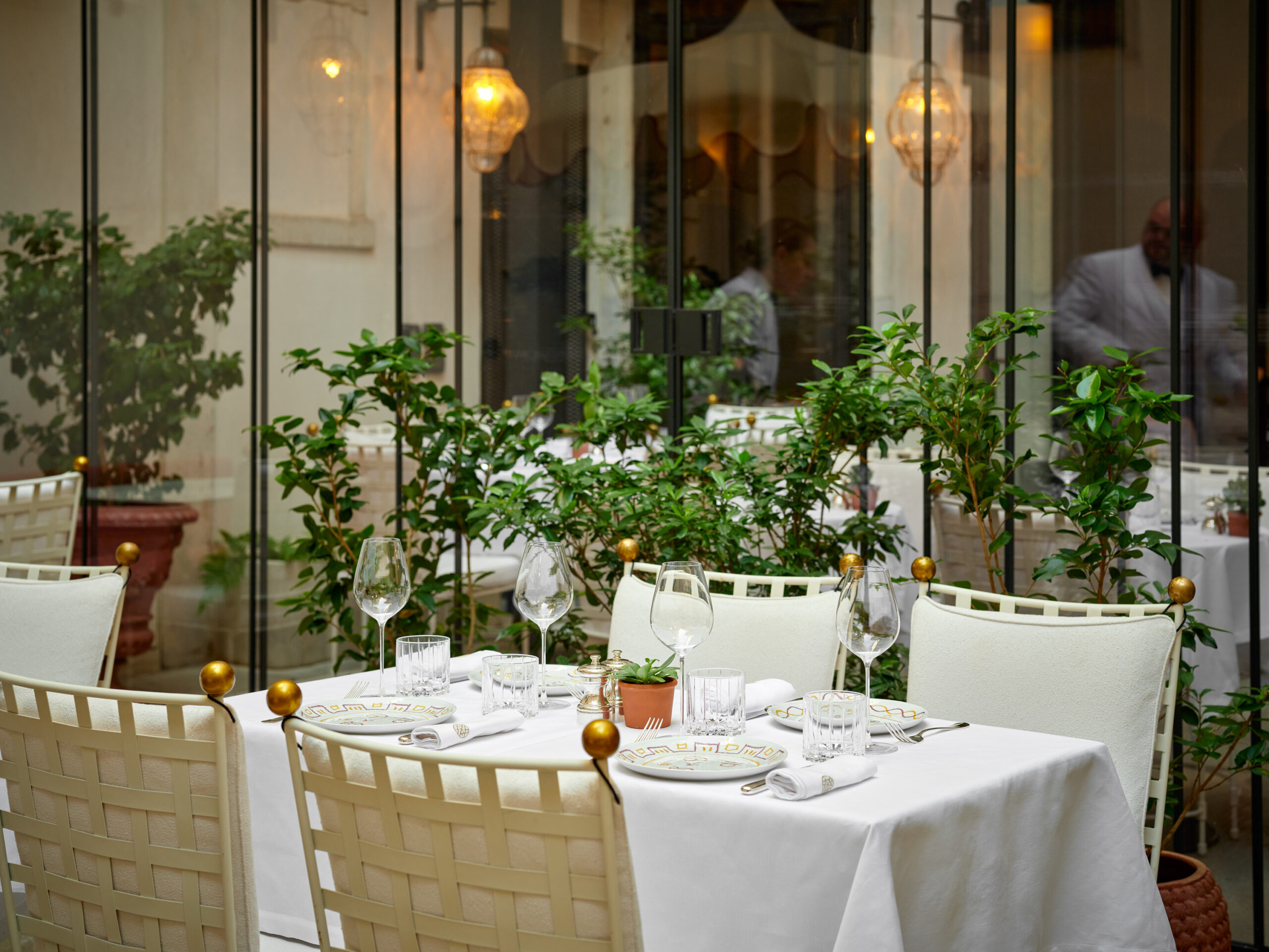 Vue du patio élégant du Il Caffè Nolinski Venezia, avec mobilier raffiné et ambiance lumineuse.